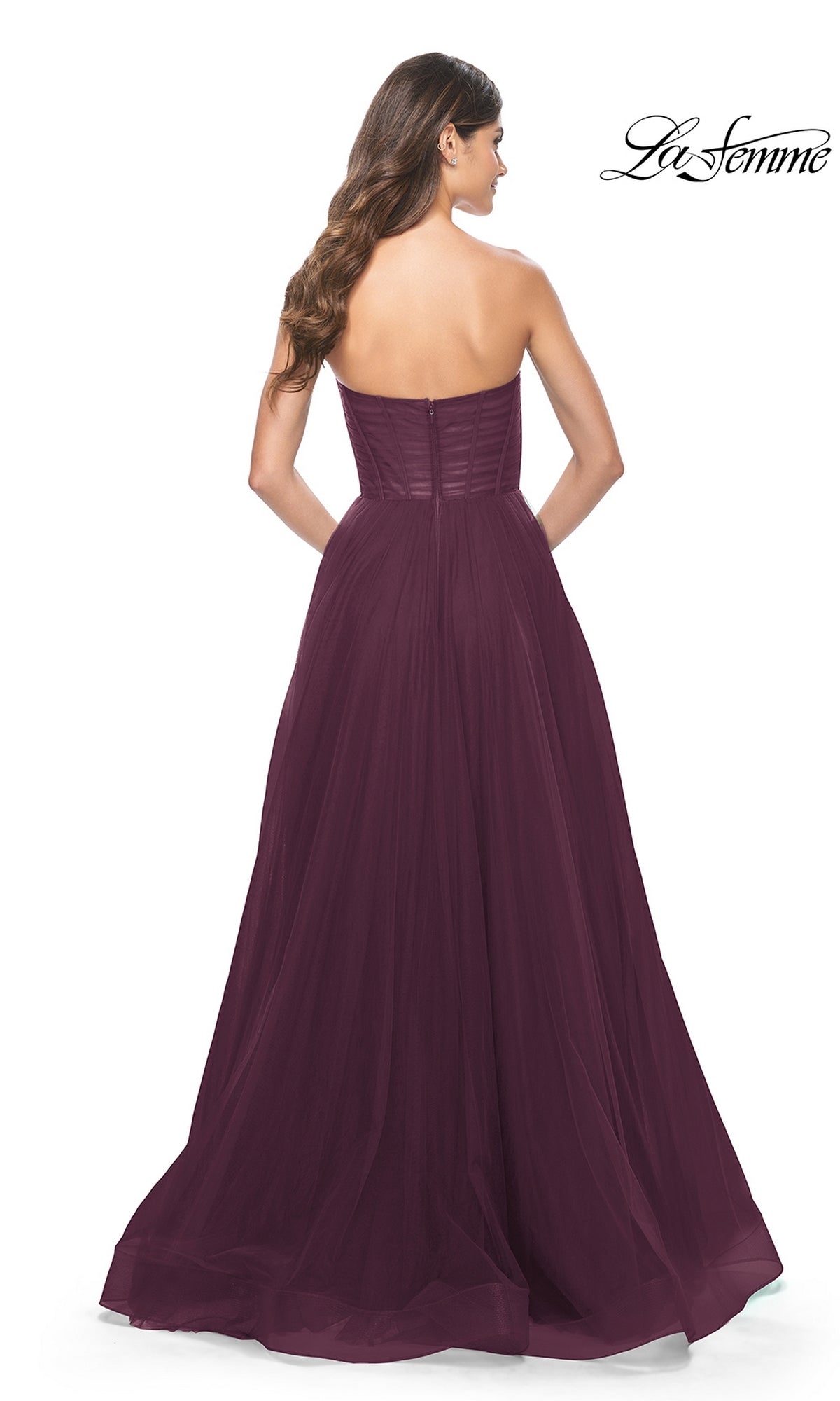 Woman seen from the back wearing the La Femme Strapless Long A-Line Prom Dress 31971 in dark purple, featuring a fitted bodice and floor-length flowing skirt.